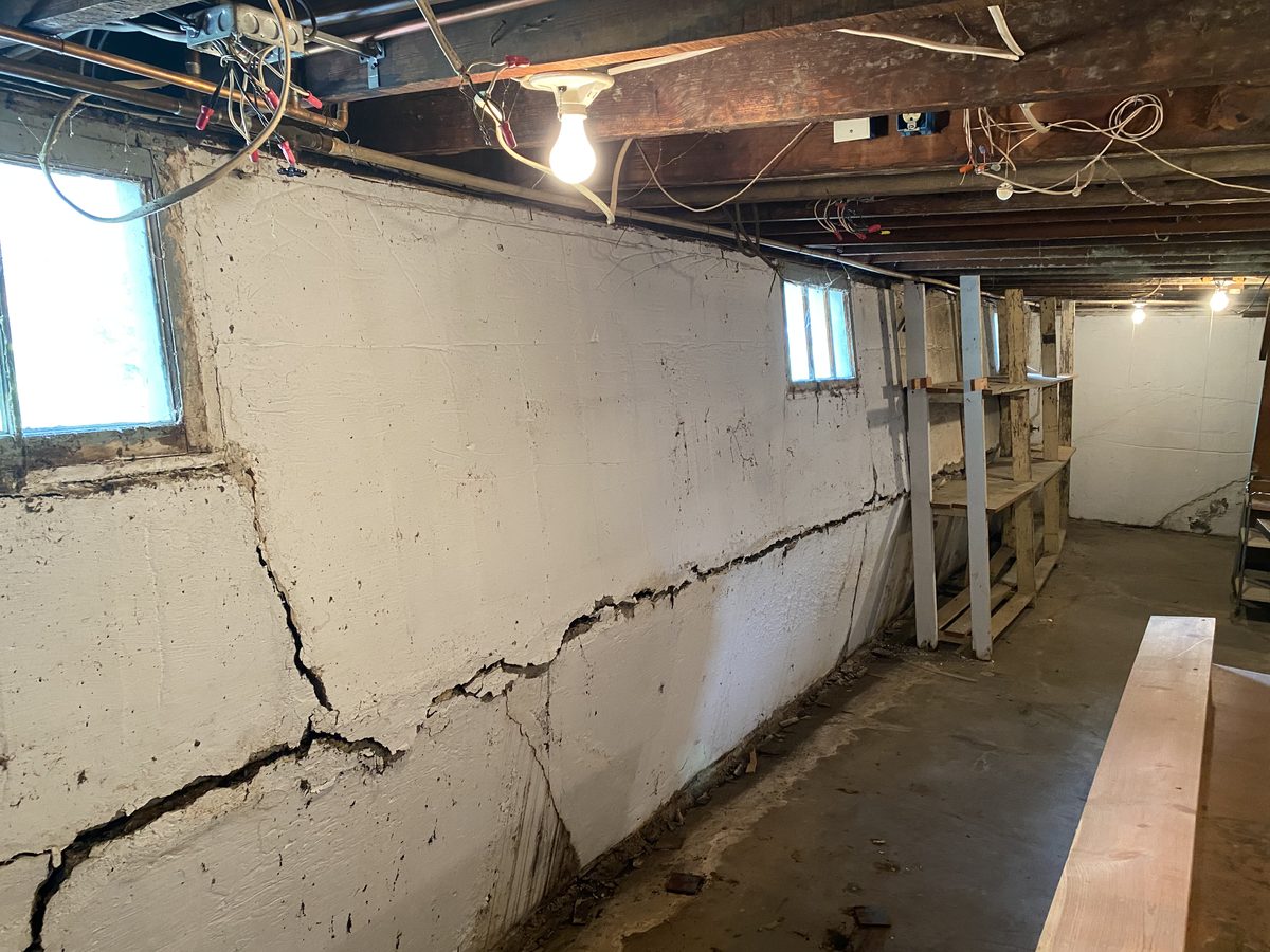Basement wall bowing inward with a long horizontal crack partway up
